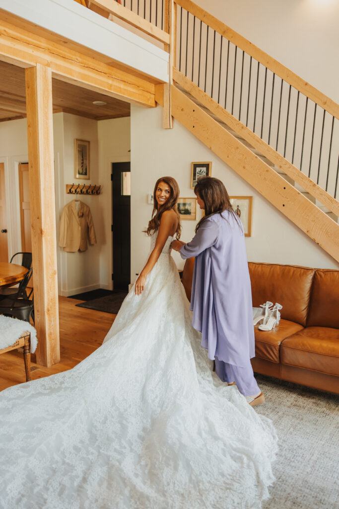 Mother helps bride into dress