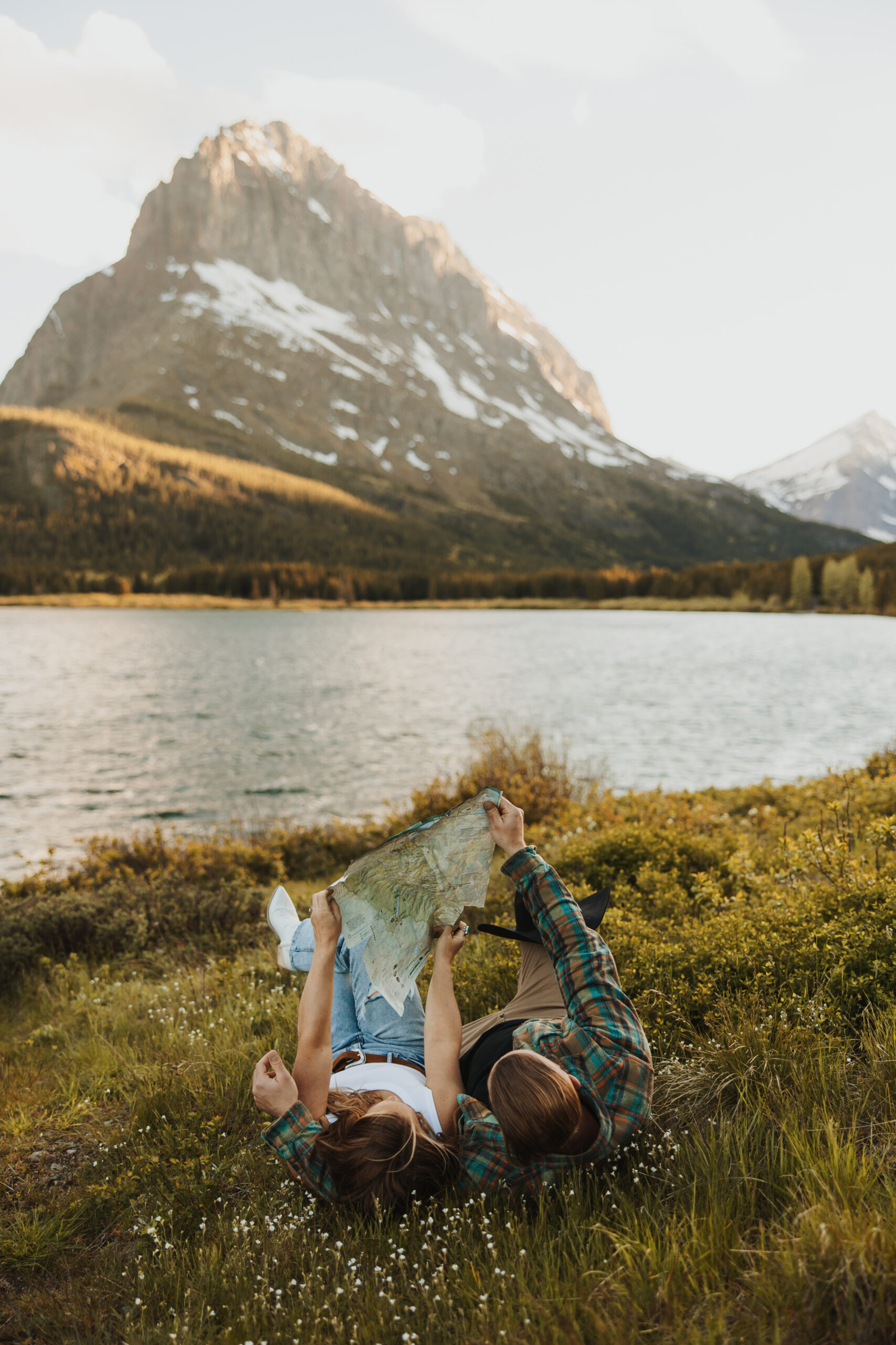 Couple looking at map for their next adventure in the mountains of Many Glacier in Glacier National Park Montana