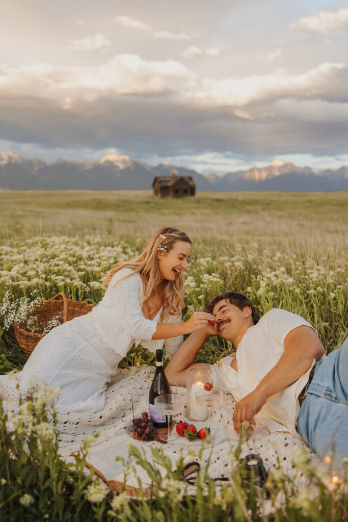 Couple in love enjoying a strawberry picnic in a wildflower field in Montana