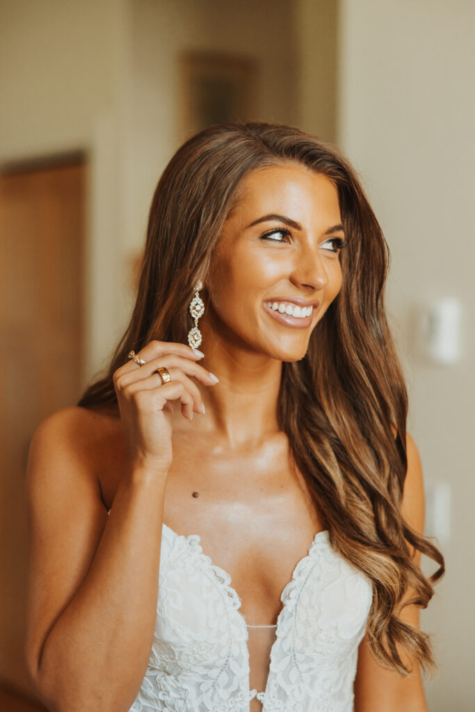 Bride putting on earrings