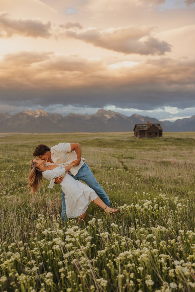 Engaged couple dancing at sunset in a wildflower field