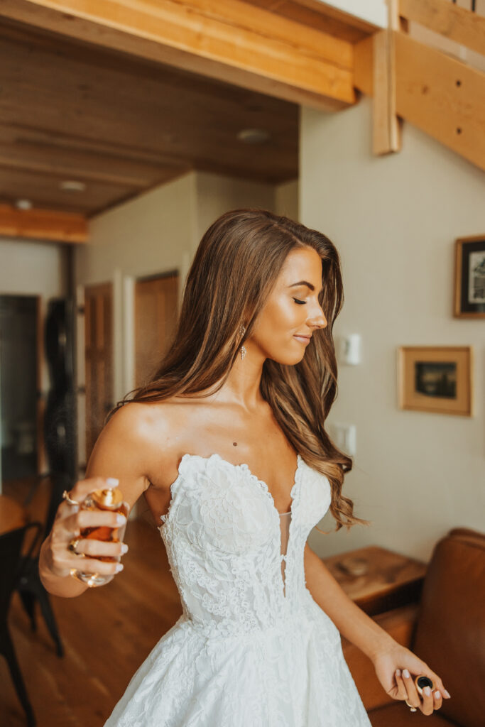 Bride spraying perfume on her wedding day