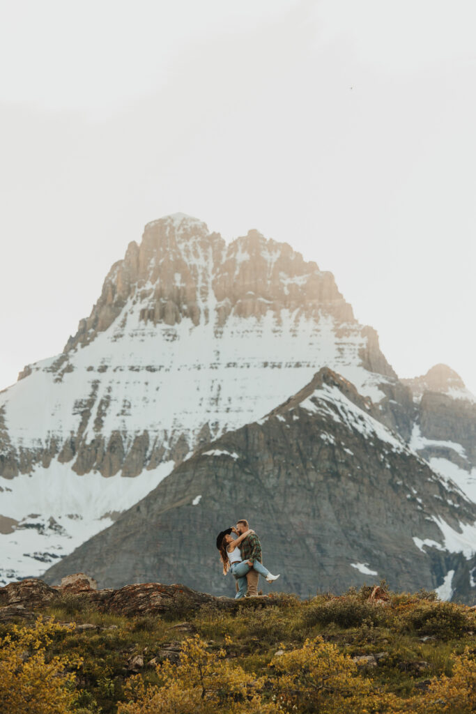 Couple embracing on a cliff in Many Glacier