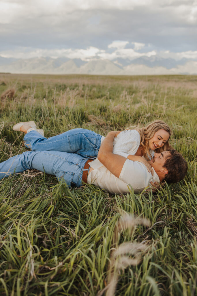 couple rolling around in a montana field in love
