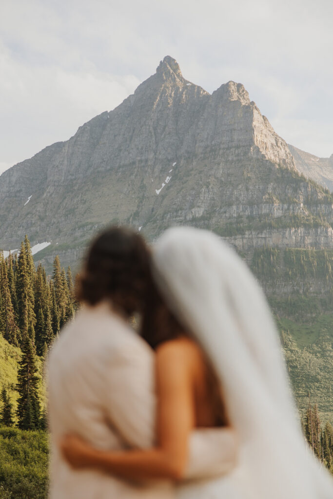 bride and groom admiring mountain in glacier