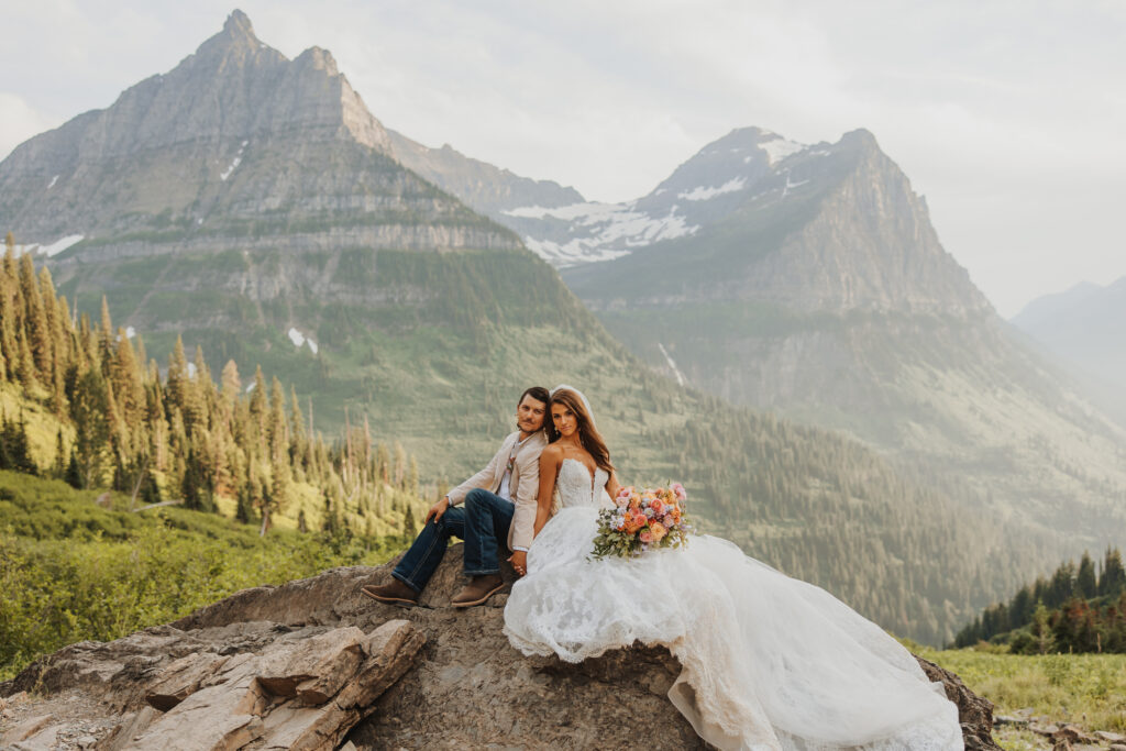 bride and groom on rock in glacier park