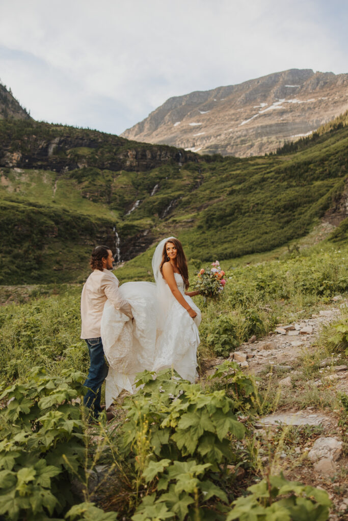 groom helping bride with her dress